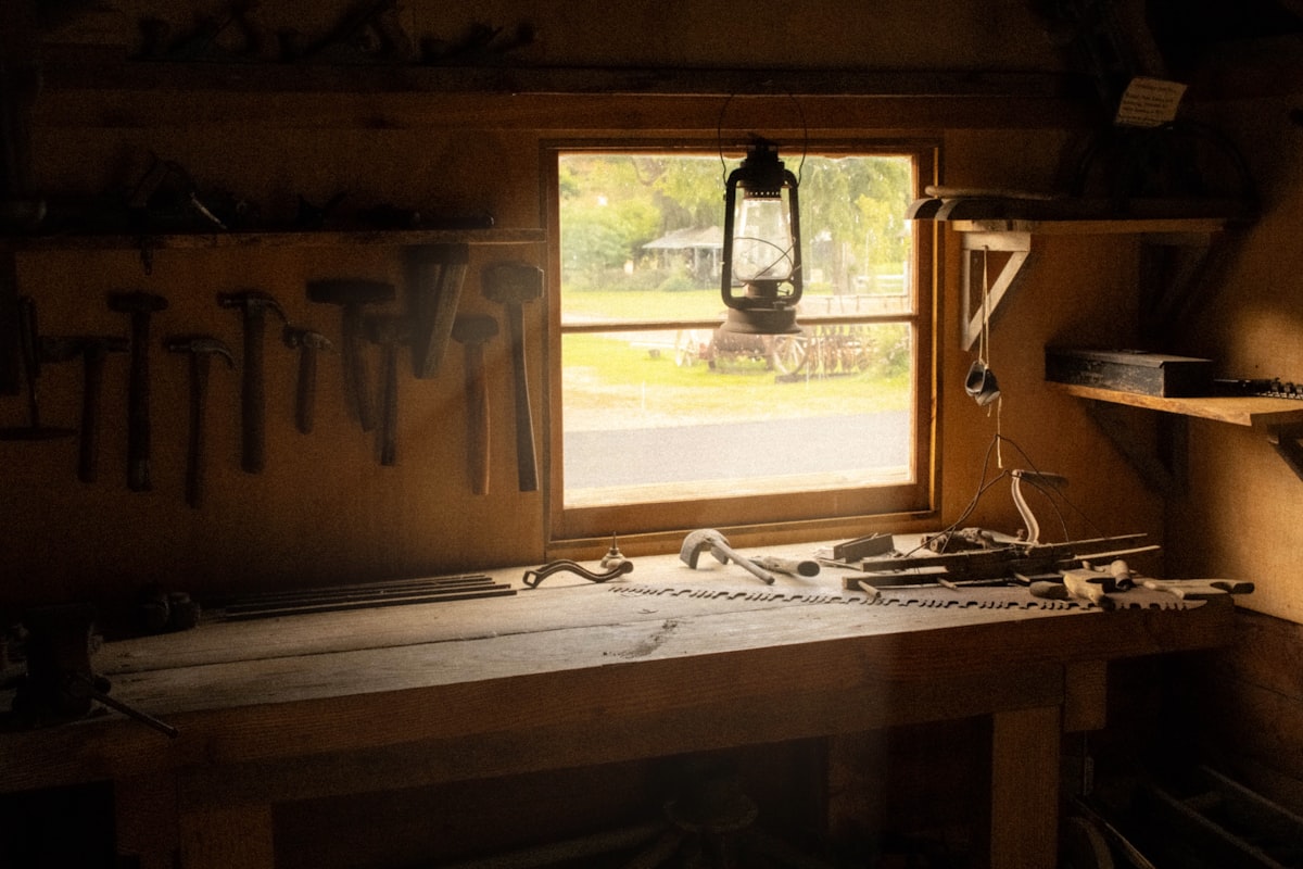 A craftsman working at a workshop bench with hand tools and a partially finished decorative piece
