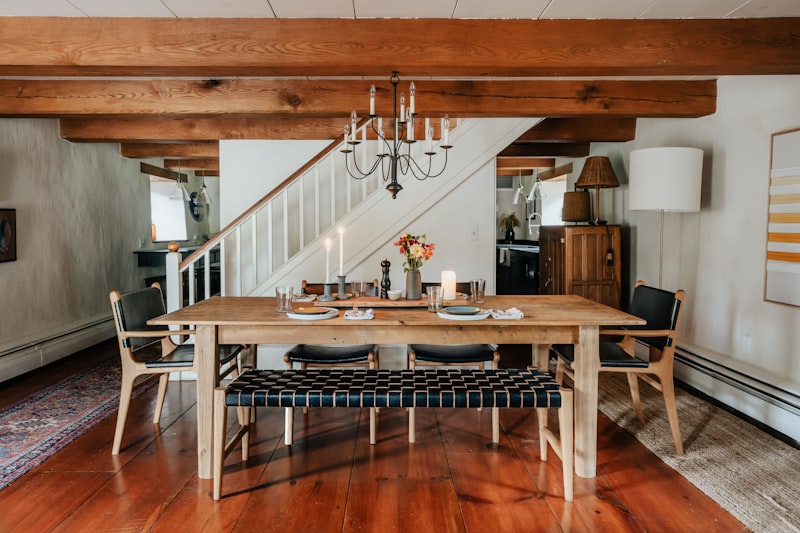 Farmhouse dining table with exposed beam ceiling and iron chandelier